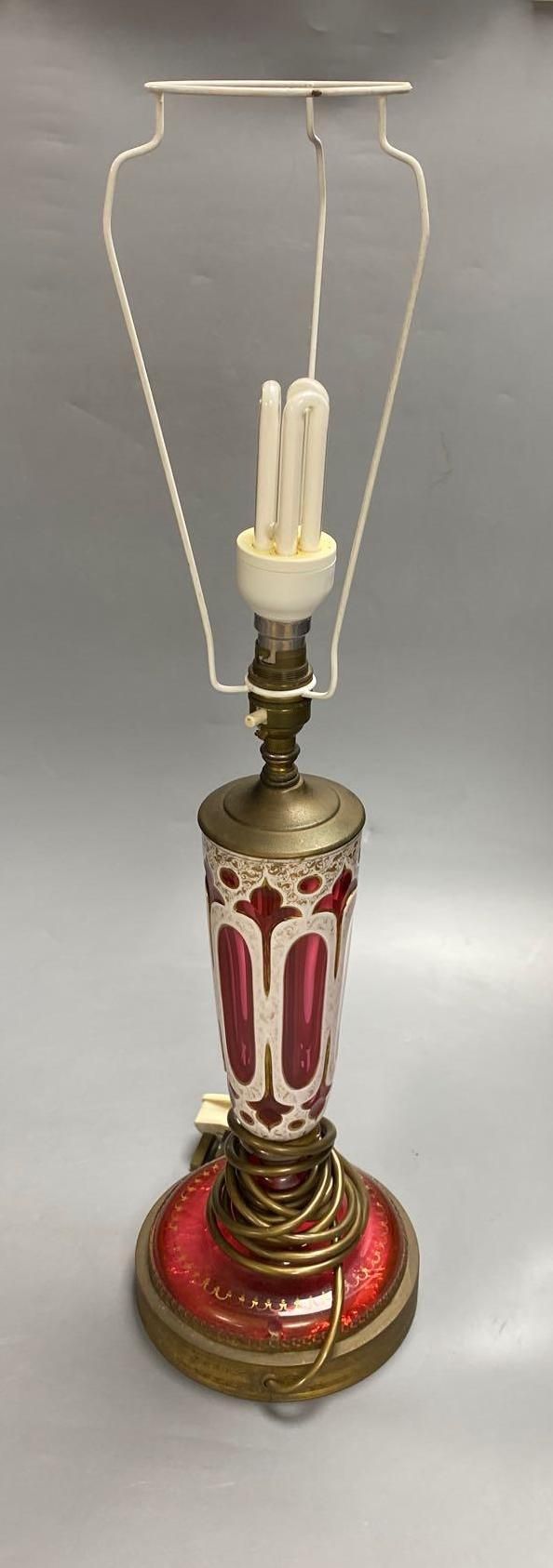 A 19th century Bohemian overlay ruby glass lamp, on engraved brass plinth, 34cm excluding light fittings